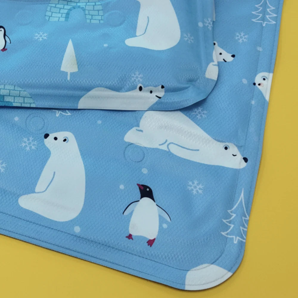 Blue Pet Cooling mat with polar bear and penguin designs on a yellow background